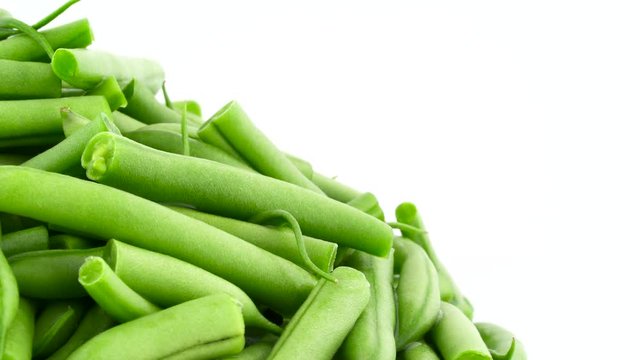 Macro shooting of fresh cut green beans pile. Half frame. Slowly rotating on the turntable. isolated on the white background. Close-up.