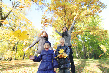 Happy family playing with autumn leaves