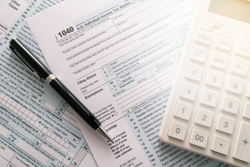 Fototapeta premium a pen to fill out an annual tax bill with a calculator to calculate the tax rate. as background business concept and finance concept with copy space for your text or design.