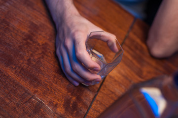 Close-up of male hands with glass of alcohol. Alcohol addiction.