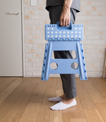 Colorful plastic folding step chair. Over light background. Cozy interior design.