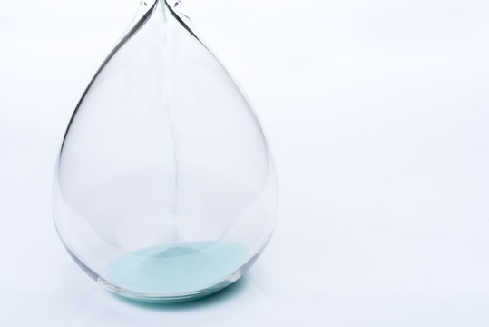 Hourglass on white background. Sand falls inside the flask.