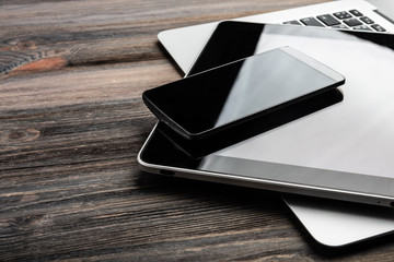 keyboard with phone and tablet pc on wooden desk