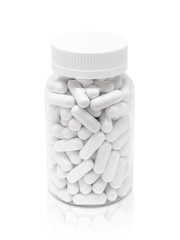 white medicine or supplement capsules in transparent plastic bottle