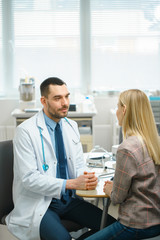Obraz premium In Medical Office Friendly Doctor Talks with a Beautiful Blonde Woman. Health Care Professional Consultation in the Bright Modern Office.