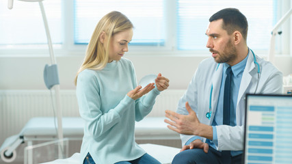 Plastic / Cosmetic Surgeon Shows Female Patient Breast Implant Samples and Talk About Her Future Surgery. Modern Hospital with Technologically Advanced Medical Equipment.