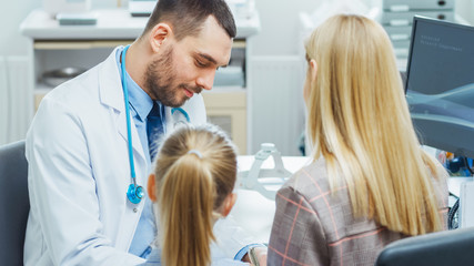 Mother with Her Cute Little Girl Have Doctor's Appointment. Friendly Pediatrician Smiles and Writes Prescription from the Illness. Modern and Bright Medical Doctor's Office.