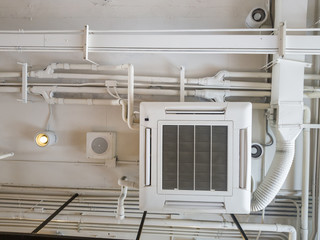 White Industrial air conditioner cooling pipe with plumbing at ceiling. Ventilation system ceiling air duct.