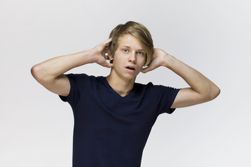 Young man wearing black t-shirt with surprised expression on face against white background