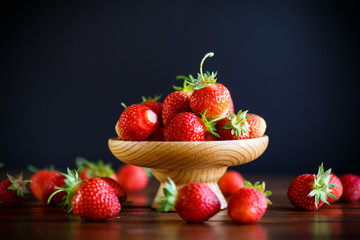 ripe red organic strawberry on a wooden table
