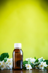 Essential aroma oil with jasmine on a green
