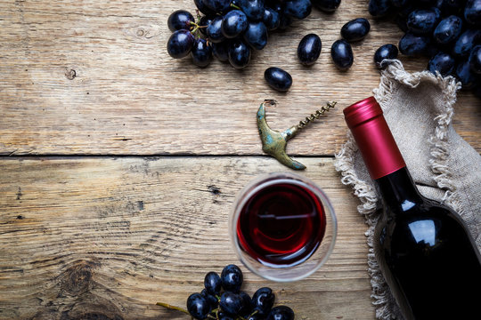 A bottle of red wine with grapes
