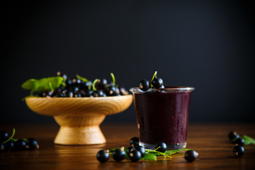 sweet jam of black currant berries on a wooden background