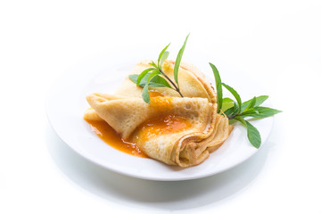 sweet thin pancakes with jam in a plate