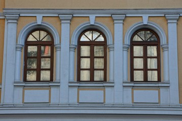 Obraz premium three brown windows on the concrete wall of the building