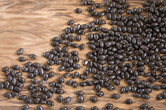 Raw black beans on the wooden background - Phaseolus vulgaris' Black turtle © Luis Echeverri Urrea