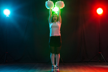 Cheerleading happy girl dancing on dark background © satura_