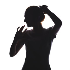 silhouette of a girl listening to music in headphones, young woman relaxing on a white isolated background