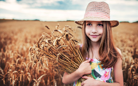 Girl with a hat in the wheat field
