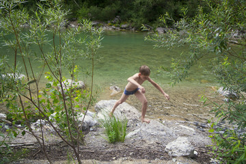 Fototapeta na wymiar Boy getting out of the river