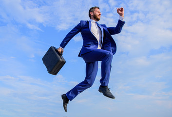 Success in business demands supernatural efforts. Businessman with briefcase jump high in motion...