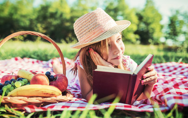 Picnic time. Little girl enjoying picnic in the park. Nature, lifestyle