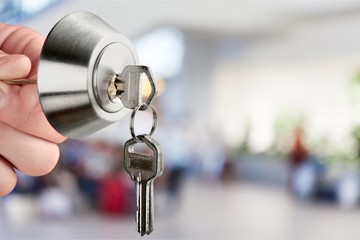 Hand with house key and door lock