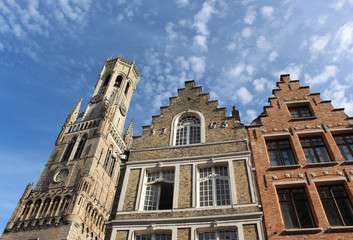Bell tower of Belfry of Bruges and two facades of houses in the centre of Bruges, Belgium.