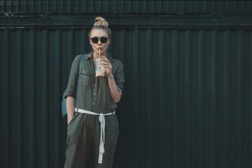 Progressive woman, wearing sunglasses with a glass of refreshing