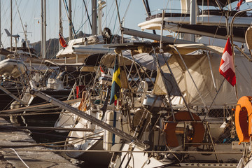 Detail of the rears of the moored yachts docking in harbor of the Zakynthos island during the sunrise