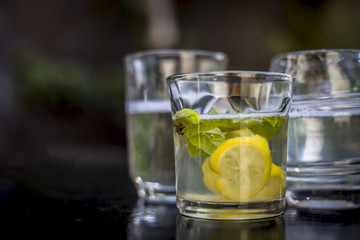 Mojito drink in a transparent glass on wooden surface with white rum,soda,lemon juice,fresh mint leaves,ice cubes and sugar,Close up shot or top shot.