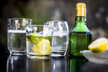 Mojito drink in a transparent glass on wooden surface with white rum,soda,lemon juice,fresh mint leaves,ice cubes and sugar,Close up shot or top shot.