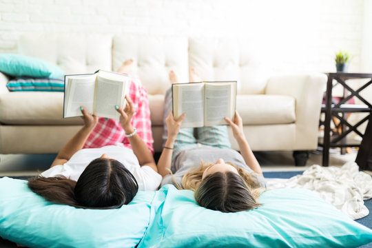 Relaxed Friends Reading Interesting Stories At Slumber Party