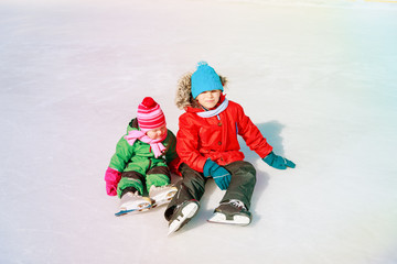 Fototapeta na wymiar happy kids- boy and girl learning to skate in winter