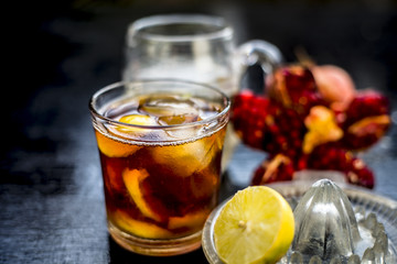 Pamosa or pomosa drink or classic mimosa drink in a transparent glass with champagne,pomegranate juice or annar ka juice,lemon juice,mint leaves,ice cubes and raw pomegranate and lemon,Close up view,