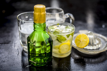 Mojito drink in a transparent glass on wooden surface with white rum,soda,lemon juice,fresh mint leaves,ice cubes and sugar,Close up shot or top shot.