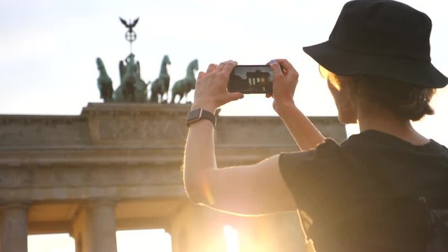 Traveler Woman Taking Picture Of Famous Tourist Attraction With Cellphone At Sunset