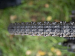 Naklejka premium Grooved black tire on a mountain bike wheel on a sunny day