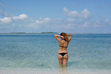 Pretty girl in bikini taking sun in amazing beach of Maldives islands