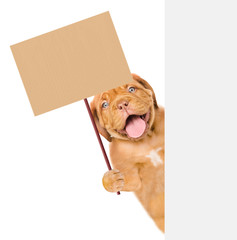 Puppy behind white banner holding blank banner mock up on wood stick. isolated on white background