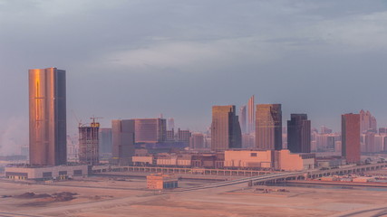 Buildings on Al Reem island in Abu Dhabi night to day timelapse from above.