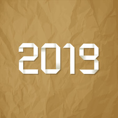 Origami 2019 symbol on a crumpled paper brown background.