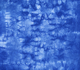 Abstract tie dyed fabric of indigo color on white cotton. Hand painted fabrics. Shibori dyeing