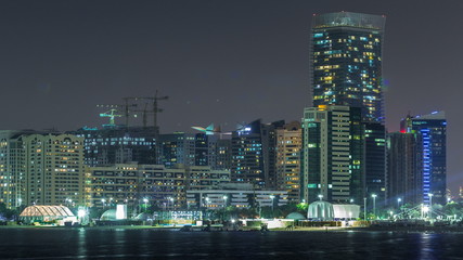 Fototapeta na wymiar Panorama view of Abu Dhabi Skyline and seafront at night timelapse, United Arab Emirates