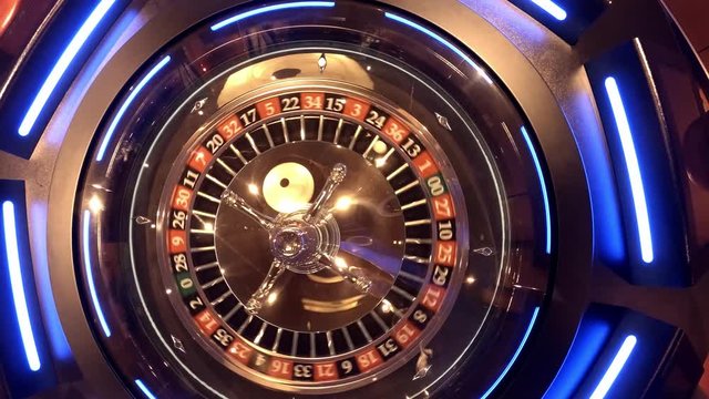 Aerial view of Roulette Wheel spinning under glass sphere with reflections of the overhead lights - Number one