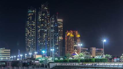 Fototapeta na wymiar Skyscrapers of Abu Dhabi at night with Etihad Towers buildings timelapse.
