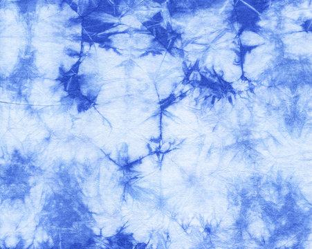 Abstract tie dyed fabric of indigo color on white cotton. Hand painted fabrics. Shibori dyeing