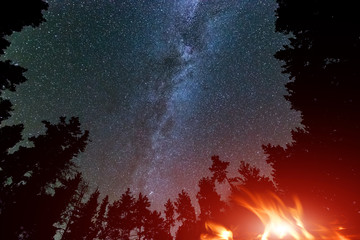 Milky Way Galaxy in sky and campfire - Powered by Adobe