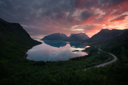 Beautiful vibrant sunset behind fjord mountains in Bergsbotn, Senja, Norway