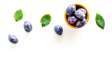 Blue plum for dessert. Purple plum and leaves pattern on white background top view copy space